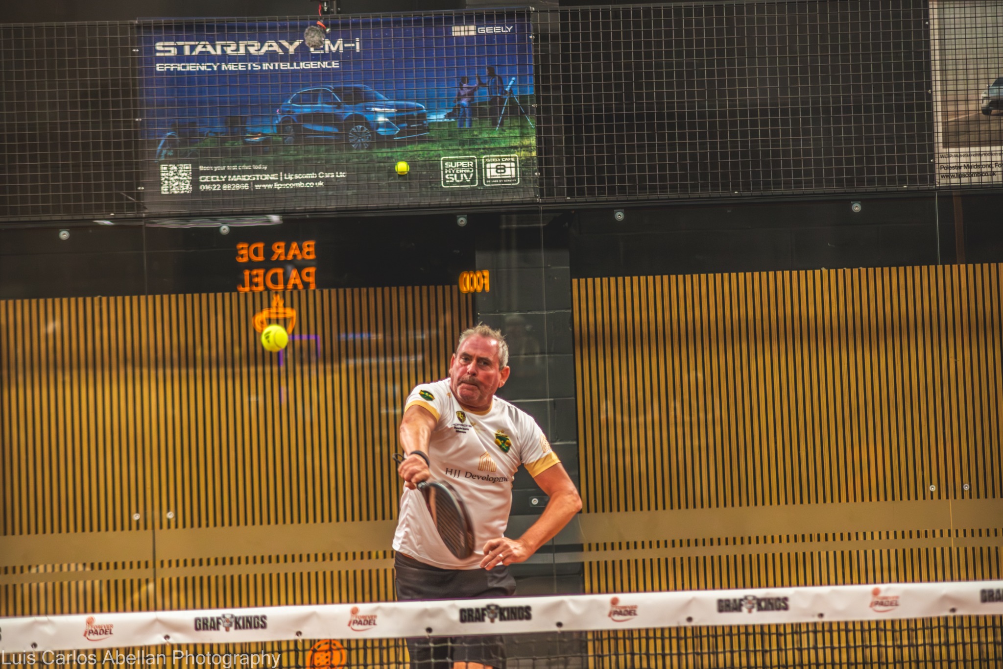 Padel player in white returning a ball near the net