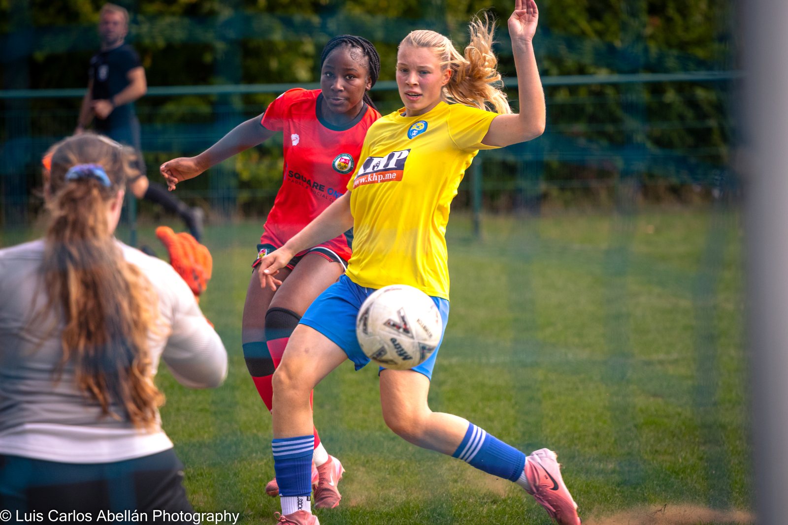 Two women footballers challenge for the ball during a match.