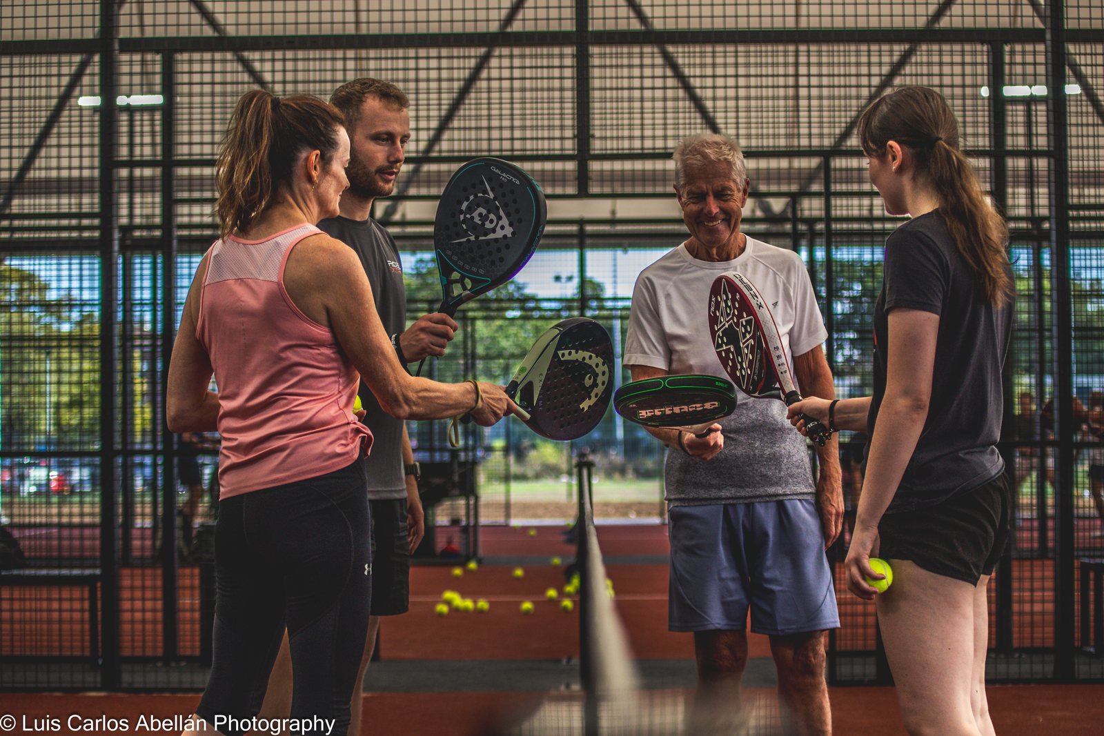 Players talk together beside the padel court.