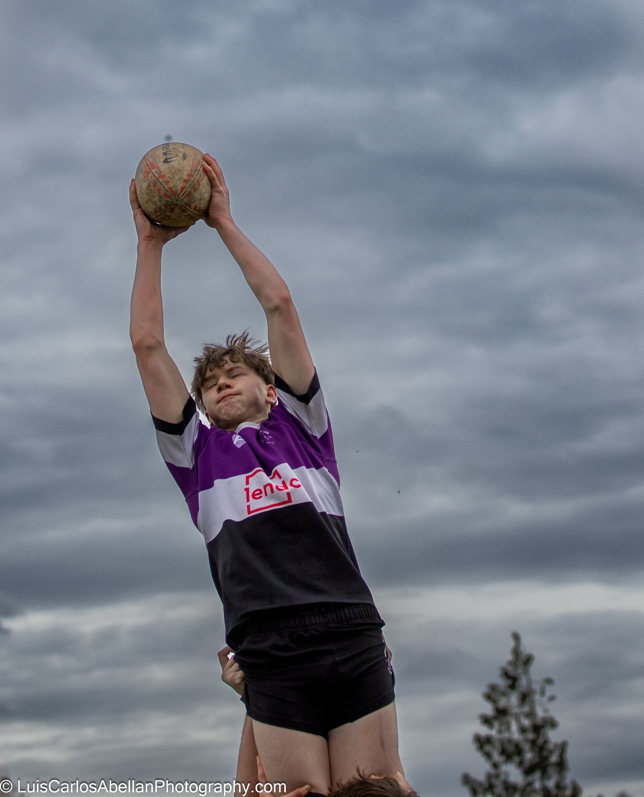 Rugby player rises to catch the ball at a lineout.