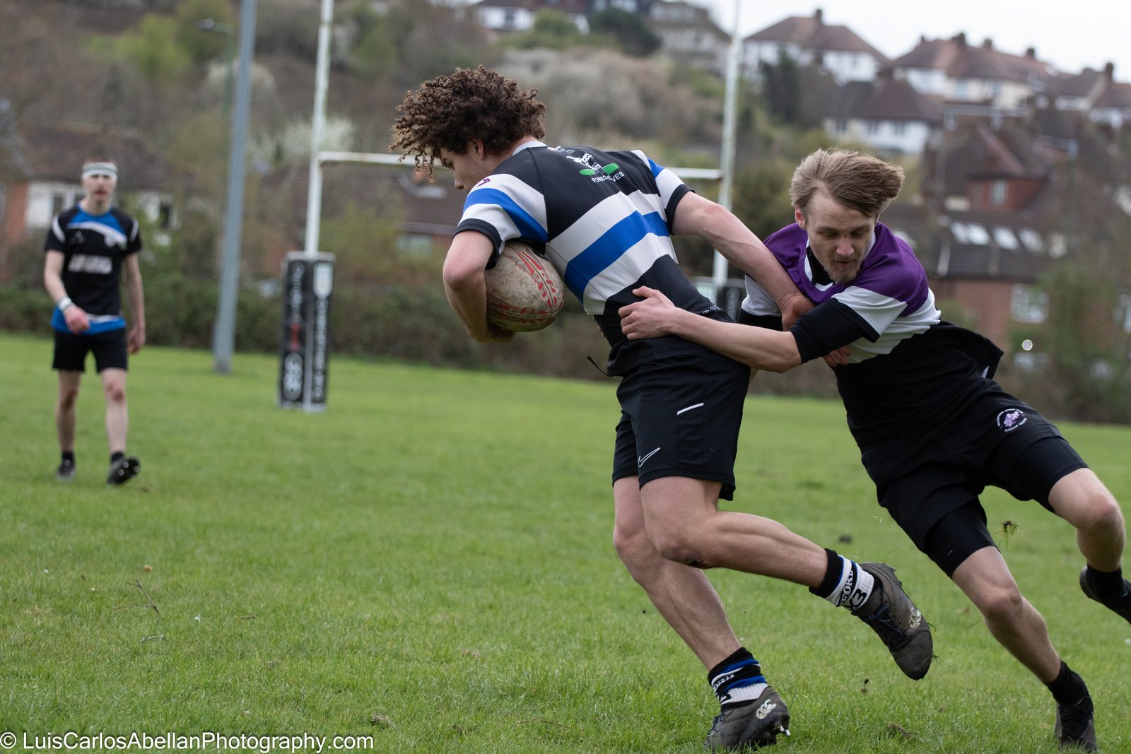 Rugby players contesting a tackle during a match